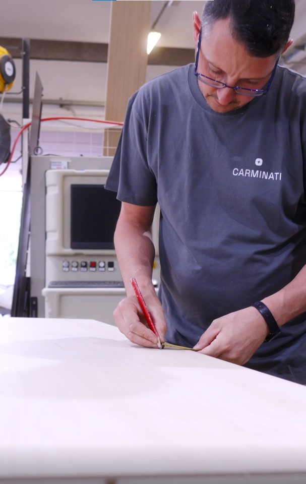 Falegname al lavoro su un progetto nella falegnameria interna di Carminati Interiors