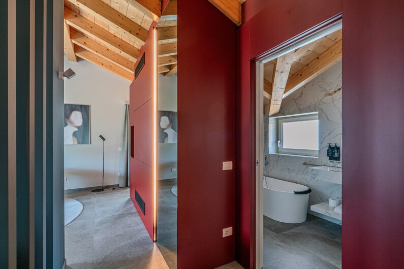 Armadiatura in legno laccata di rosso realizzata su misura per la Suite Rouge da Carminati Interiors