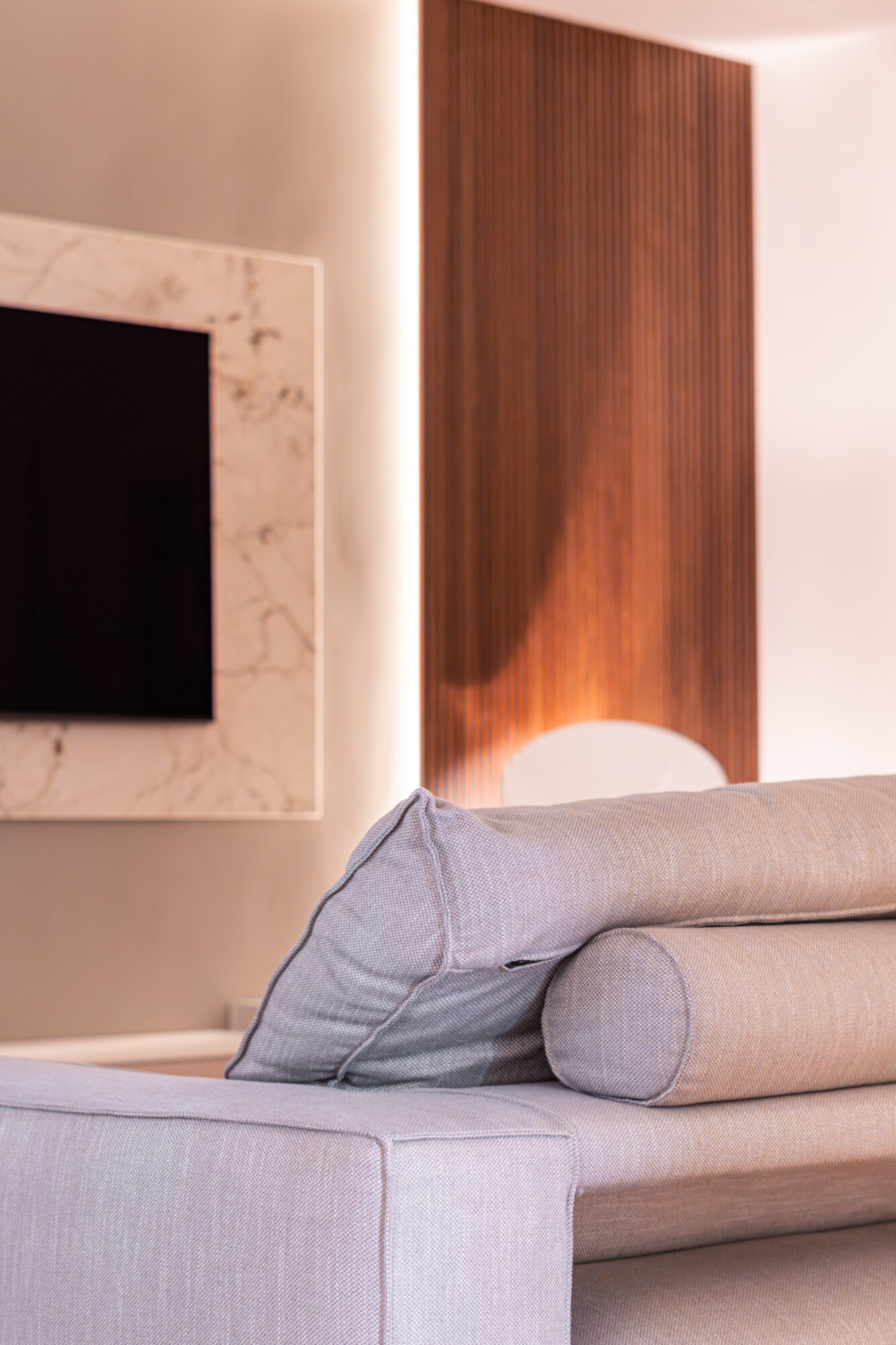 Divano e parete TV con boiserie in legno progetto Bespoke