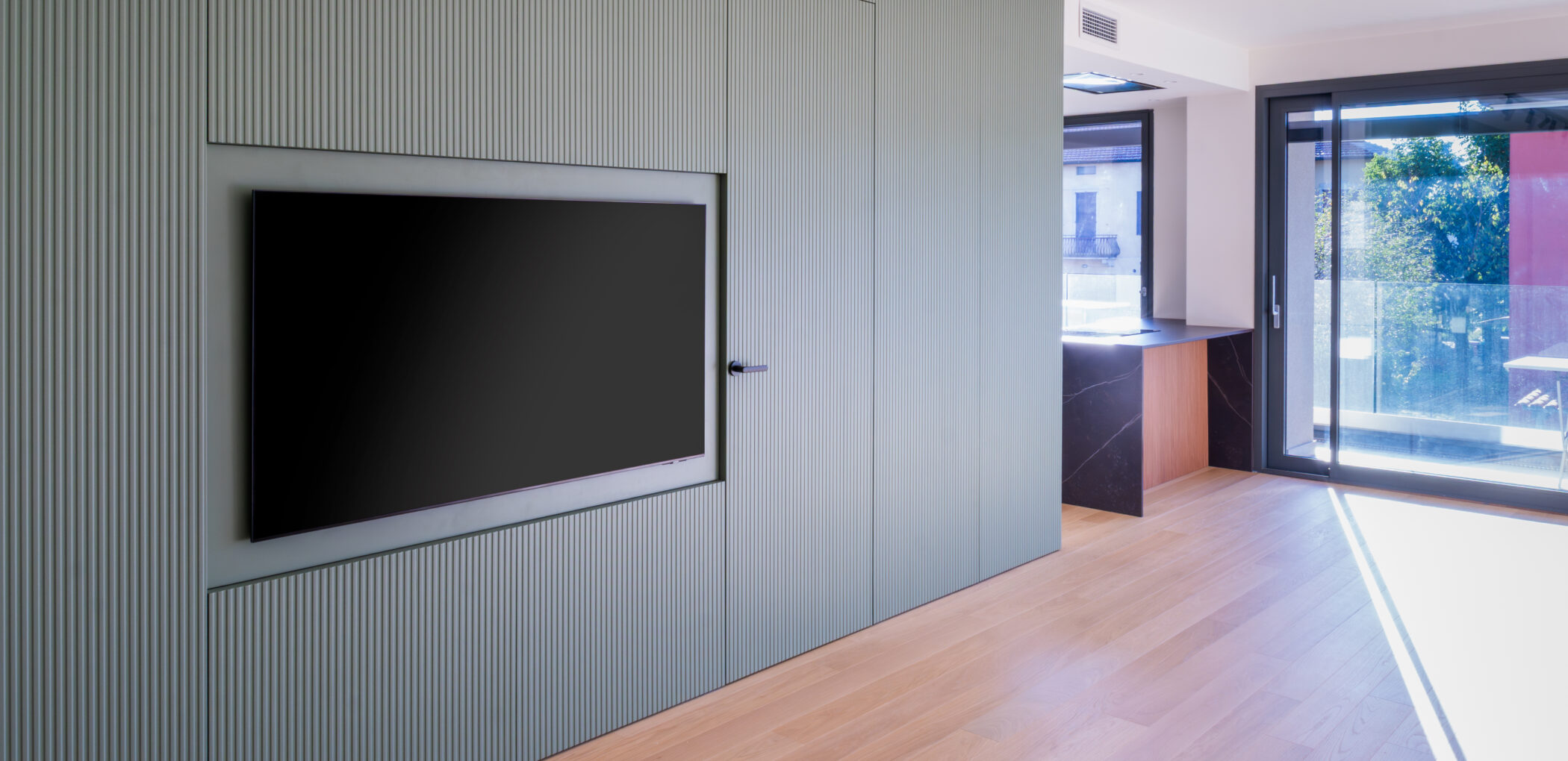 Ingresso open space con parete attrezzata realizzata su misra da Carminati Interiors Progetto Space